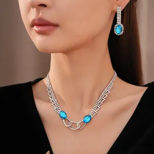 Nahaufnahme eines eleganten Strass-Schmucksets mit blauen ovalen Edelsteinen am Modell