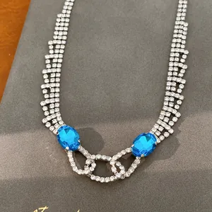 Detailansicht einer Luxushalskette mit ovalen blauen Steinen und glänzenden Strass.