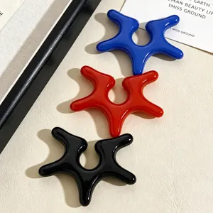 Close-up of glossy colorful acrylic ear clips featuring an irregular starfish-like shape