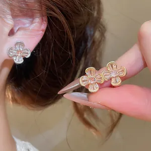 Close-up of elegant vintage flower earrings with sparkling zircons on gold-tone base