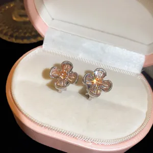 Detailed close-up view of elegant champagne zircon flower clip-on earrings in a pink gift box