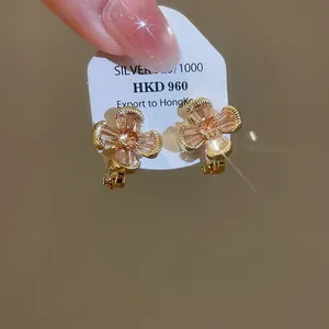 Detailed close-up of vintage flower clip-on earrings featuring shimmering orange zirconia
