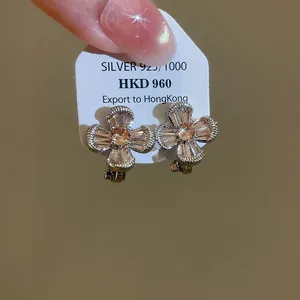Close-up of luxury vintage flower-shaped clip-on earrings featuring champagne cubic zirconia