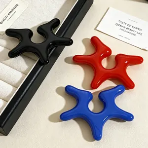 Detailed view of colorful acrylic irregular starfish ear clips in black red and blue.