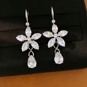 Dettaglio di orecchini a fiore con zirconi e pendenti a goccia molto scintillanti