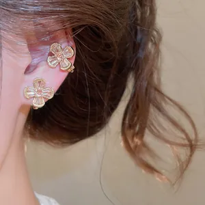 Close-up of retro zircon flower ear clips for non-pierced ears in gold finish.