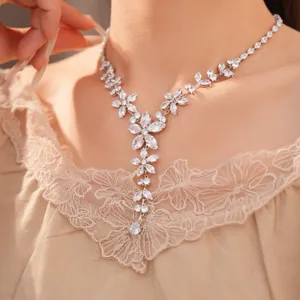 Primo piano di un'elegante collana di fiori in zirconi indossata da una modella con luce soffusa.