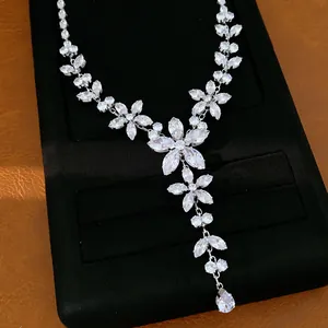 Vista dettagliata di un'elegante collana argentata con fiori di zircone e gocce di cristallo.