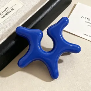 Close-up of a vibrant blue irregular starfish ear clip made of acrylic material.