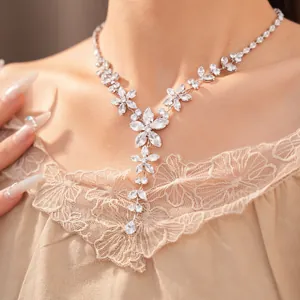 Primo piano di un'elegante collana con fiori di zirconia e pendente a goccia su modella