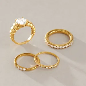Elegante set de cuatro anillos de acero inoxidable dorado para mujer con circonitas brillantes