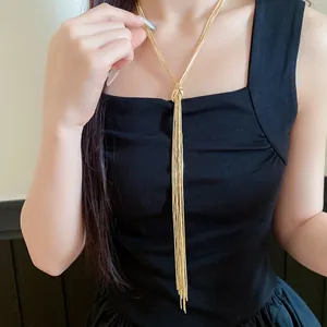 Detailopname van een elegante gouden ketting met geknoopte kwastjes op een zwart topje