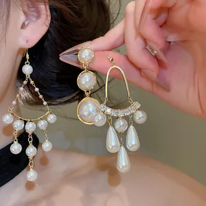 Gros plan de boucles d'oreilles style cour française avec perles et pompons dorés