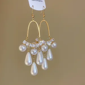 Gros plan de boucles d'oreilles perles style cour avec pampilles en forme de goutte.