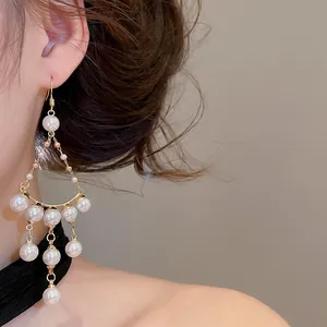 Gros plan de boucles d'oreilles pendantes à pampilles de perles de style palais