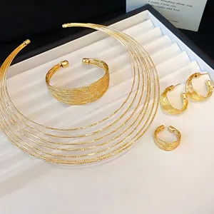 Elegante gouden meerlaagse metalen sieradenset met choker, armband, oorbellen en ring