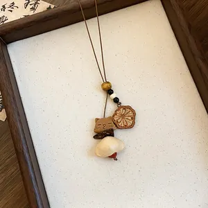 Gedetailleerde weergave van de houten berenhanger op een retro lange halsketting