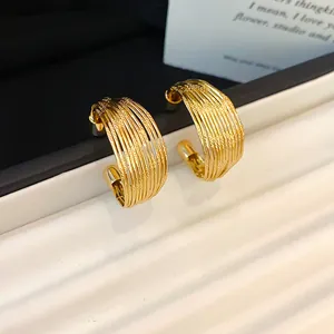 Close-up of golden multi-layer wide hoop earrings with hammered textured finish