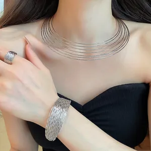 Close-up of elegant multi-layered silver metal choker, bracelet and ring jewelry set