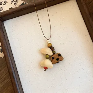 Gedetailleerd beeld van een handgemaakte houten beer hanger ketting met houten kralen.