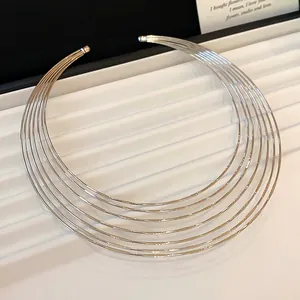 Detail view of a multi-layered silver metal choker with a minimalist tiered design.