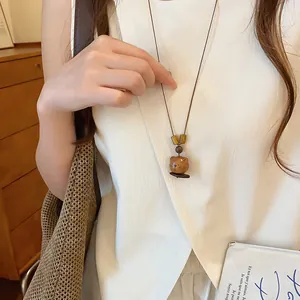 Gedetailleerd overzicht van een retro houten beer hanger ketting op een wit shirt.