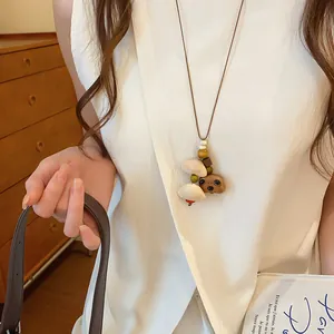 Gedetailleerde weergave van houten beer hanger aan een lange retro stijl trui ketting