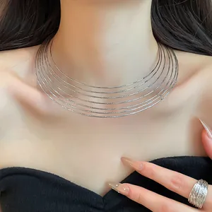 Elegant multi-layer silver metallic choker necklace with matching ring worn by model