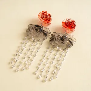 Close-up of vintage resin rose earrings with elegant long beaded tassels in a classic style