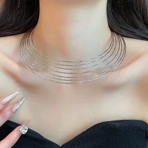 Close-up detail of a stylish multi-layer silver-tone metallic choker necklace on a model