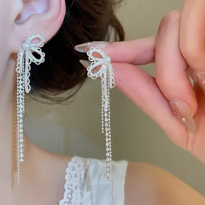Detailopname van elegante vlinder oorbellen met glanzende strassteentjes en parels