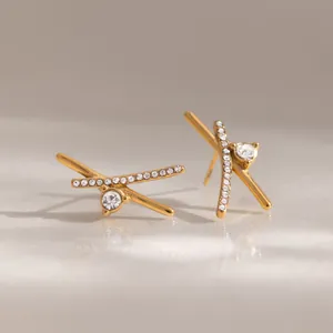 Orecchini a lobo a forma di X color oro con pavé di pietre e cristallo centrale.
