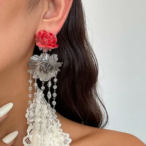 Close-up of vintage resin rose earrings with transparent floral tassels on a model.