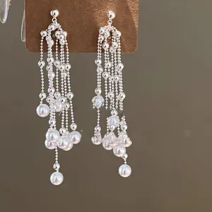 Detailopname van elegante Franse kwastjesoorbellen met witte parels en zilveren kralen