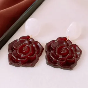 Detailansicht von Vintage-Ohrringen aus Harz in Dunkelrot und Weiß im Kontrastdesign.