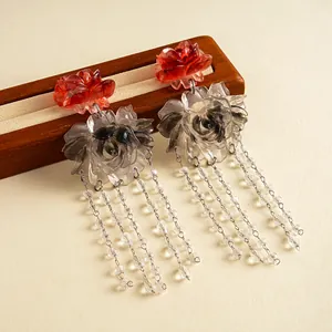 Vintage resin marbled flower tassel earrings with clear beads on a wooden display