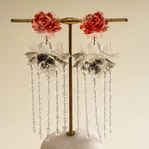 Detailed view of vintage resin rose earrings with translucent glass flower tassels