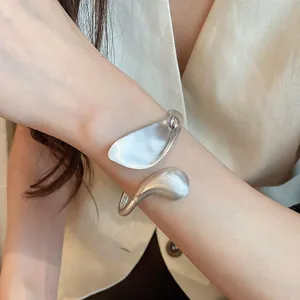 Close-up of a silver geometric leaf cuff bracelet featuring a unique matte and glossy finish.