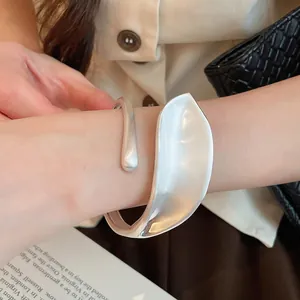 Detailed view of a wide silver leaf cuff bracelet featuring a unique matte brushed finish