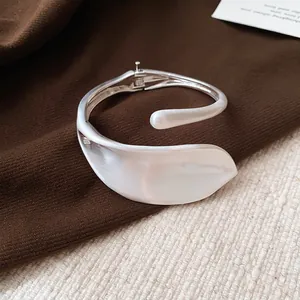 Close-up of silver-tone leaf design cuff bracelet with matte and glossy finish