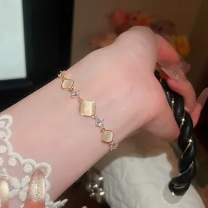 Detailopname van een elegante goudkleurige verstelbare armband met vierkante kattenoogstenen