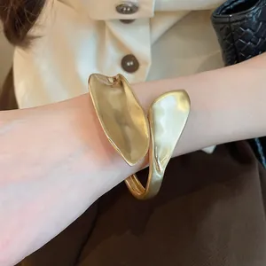 Detailed macro shot of a vintage gold matte finish leaf-shaped geometric cuff bracelet