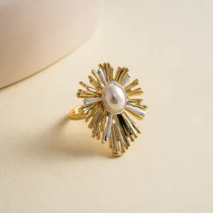 Vista macro di un anello vintage placcato oro 18k con perla centrale e dettagli raggiera