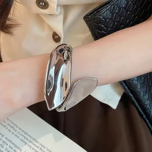 Close-up of geometric leaf silver cuff bracelet featuring unique shiny and matte metallic finishes