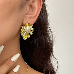 Dettaglio ravvicinato di orecchini vintage dorati con perla centrale sul modello.