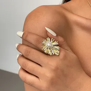 Dettaglio ravvicinato di un anello a fiore vintage placcato oro 18k con perla ovale