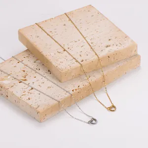 Detalle de colgantes de corazón retorcido en cadenas minimalistas de acero inoxidable oro y plata