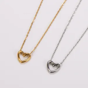Primer plano de elegantes collares de corazón calado de acero inoxidable en oro y plata