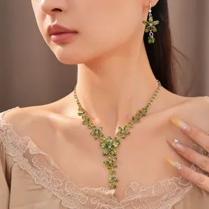 Close-up of elegant green floral zircon necklace and earring set on female model