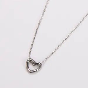 Vista detallada del collar con colgante de corazón de acero inoxidable con diseño calado